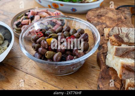 Olives marinées et marinées, artichauts, légumes sur table en bois, variété de savoureuses entrées italiennes, antipasti, tapas en gros plan Banque D'Images