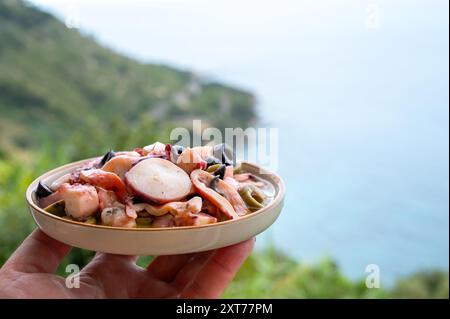 Savoureux antipasti salade ou plat de fruits de mer, poulpe grillé style ligure avec olives vertes et noires servies dans le restaurant italien Banque D'Images