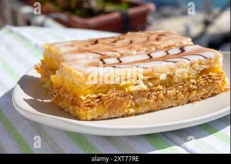 Portion de gâteau français mille feuilles, tranche de vanille ou de crème anglaise, pâte feuilletée Napoléon recouverte de crème pâtissière servie en plein air à Port Grimaud, France Banque D'Images