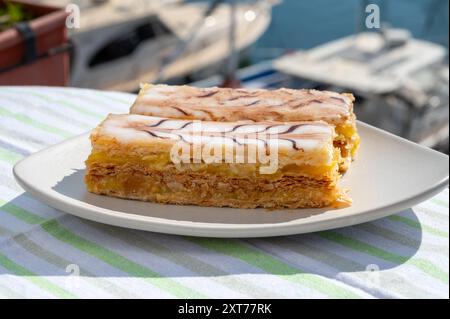 Portion de gâteau français mille feuilles, tranche de vanille ou de crème anglaise, pâte feuilletée Napoléon recouverte de crème pâtissière servie en plein air à Port Grimaud, France Banque D'Images