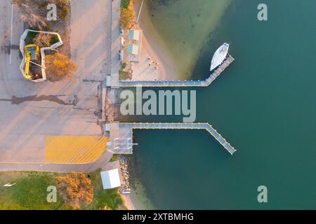 Vue aérienne d'un yacht amarré sur une jetée le long d'une rampe d'accès à Lake Entrance dans le Gippsland, Victoria, Australie Banque D'Images