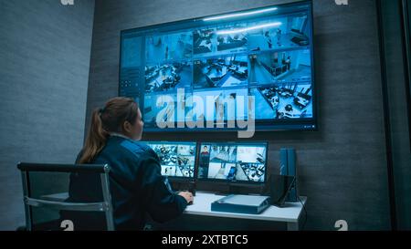 Opérateur de vidéosurveillance féminin contrôle les caméras de surveillance de bureau avec reconnaissance faciale à l'aide d'un ordinateur, fonctionne dans un centre de surveillance moderne. Plusieurs moniteurs et grand écran numérique affichent des séquences vidéo de sécurité. Banque D'Images