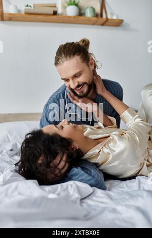 Un couple aimant se détend ensemble sur un lit. Banque D'Images