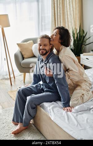 Un couple aimant se détend sur un lit à la maison, appréciant les uns les autres compagnie. Banque D'Images