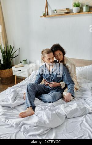 Un couple aimant se détend sur leur lit dans leur maison, profitant d'un moment de paix ensemble. Banque D'Images