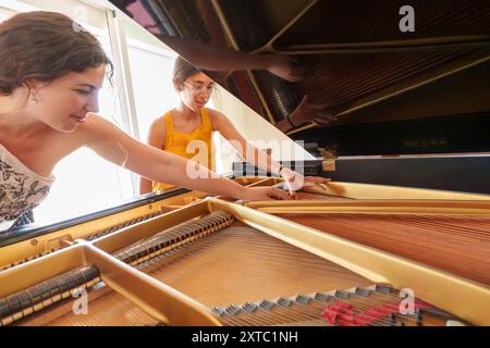 Professeur de piano enseignant à une adolescente le fonctionnement interne d'un piano à queue Banque D'Images