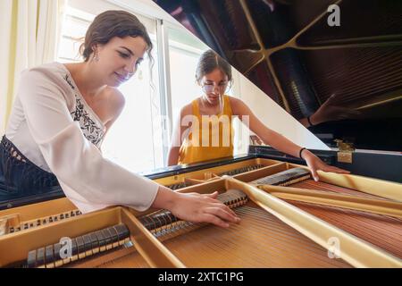 Professeur de piano enseignant à une adolescente le fonctionnement interne d'un piano à queue Banque D'Images