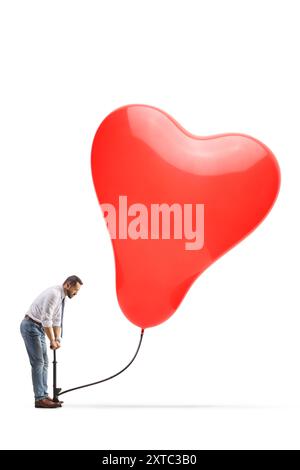 Homme d'affaires pompant un grand ballon en forme de coeur rouge avec une pompe manuelle isolée sur fond blanc Banque D'Images