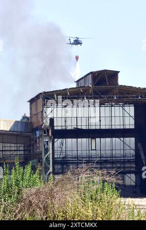 Ostrava, République tchèque. 14 août 2024. Un hélicoptère Sikorsky UH-60A Black Hawk intervient dans un incendie dans un complexe industriel de la société Skaltop à Vitkovice, Ostrava, République tchèque, août 2024. 12 unités de pompiers et 22 pièces d'équipement interviennent. Crédit : Petr Sznapka/CTK photo/Alamy Live News Banque D'Images