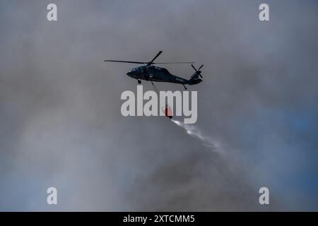 Ostrava, République tchèque. 14 août 2024. Un hélicoptère Sikorsky UH-60A Black Hawk intervient dans un incendie dans un complexe industriel de la société Skaltop à Vitkovice, Ostrava, République tchèque, août 2024. 12 unités de pompiers et 22 pièces d'équipement interviennent. Crédit : Vladimir Prycek/CTK photo/Alamy Live News Banque D'Images