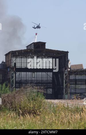 Ostrava, République tchèque. 14 août 2024. Un hélicoptère Sikorsky UH-60A Black Hawk intervient dans un incendie dans un complexe industriel de la société Skaltop à Vitkovice, Ostrava, République tchèque, août 2024. 12 unités de pompiers et 22 pièces d'équipement interviennent. Crédit : Petr Sznapka/CTK photo/Alamy Live News Banque D'Images