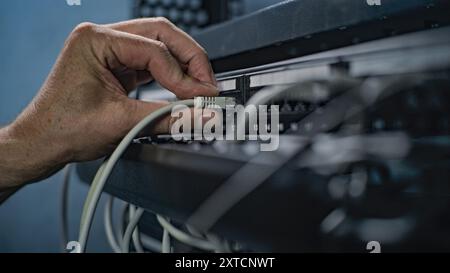 Maintenance des serveurs LAN ou Web. Gros plan de l'administrateur système connectant les câbles au rack du serveur, travaillant dans la salle des serveurs. Exploitation des systèmes et réseaux d'information. Centre de stockage de données. Banque D'Images