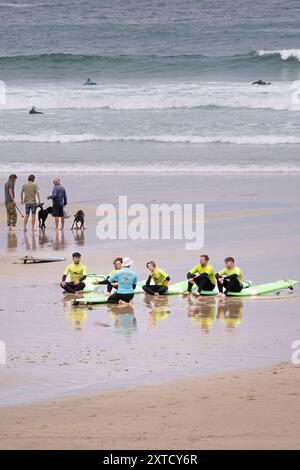 Une leçon de surf sur GT Great Western Beach. Un groupe de novices de surf avec leur instructeur de surf de l'Escape Surf School à Newquay en Cornouailles Banque D'Images