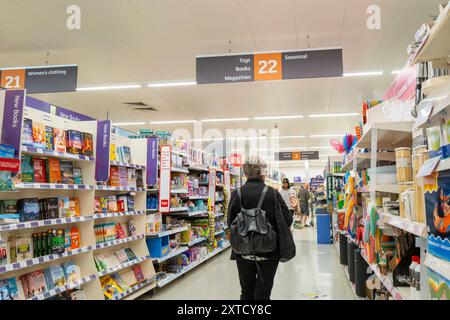 Clients Shoppers marchant le long d'une allée à l'intérieur d'un magasin Sainsburys au Royaume-Uni. Banque D'Images