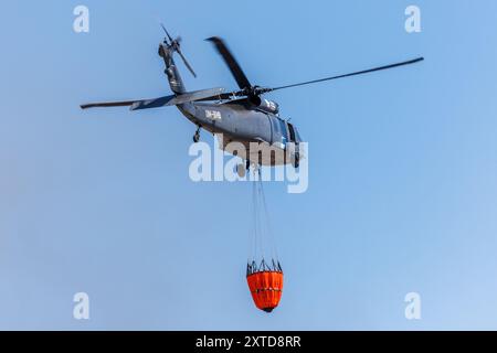 Ostrava, République tchèque. 14 août 2024. Un hélicoptère Sikorsky UH-60A Black Hawk intervient dans un incendie dans un complexe industriel de la société Skaltop à Vitkovice, Ostrava, République tchèque, août 2024. 12 unités de pompiers et 22 pièces d'équipement interviennent. Crédit : Petr Sznapka/CTK photo/Alamy Live News Banque D'Images