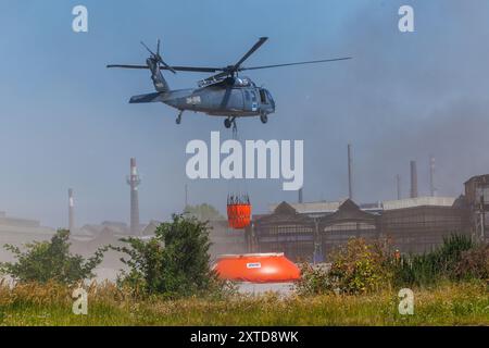 Ostrava, République tchèque. 14 août 2024. Un hélicoptère Sikorsky UH-60A Black Hawk intervient dans un incendie dans un complexe industriel de la société Skaltop à Vitkovice, Ostrava, République tchèque, août 2024. 12 unités de pompiers et 22 pièces d'équipement interviennent. Crédit : Petr Sznapka/CTK photo/Alamy Live News Banque D'Images