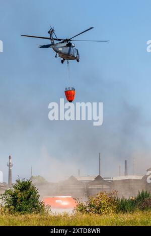 Ostrava, République tchèque. 14 août 2024. Un hélicoptère Sikorsky UH-60A Black Hawk intervient dans un incendie dans un complexe industriel de la société Skaltop à Vitkovice, Ostrava, République tchèque, août 2024. 12 unités de pompiers et 22 pièces d'équipement interviennent. Crédit : Petr Sznapka/CTK photo/Alamy Live News Banque D'Images