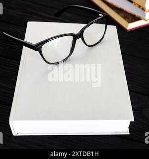 Un cahier blanc et des lunettes noires. Espace pour le texte Banque D'Images