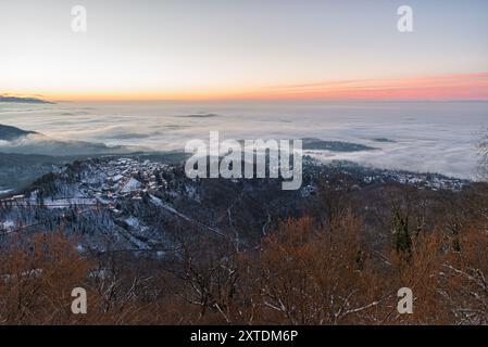 Ancien village perché avec une mer de nuages en dessous, au lever du soleil. Sacro Monte di Varese (site de l'UNESCO) avec la ville de Varèse dans le brouillard, Italie Banque D'Images