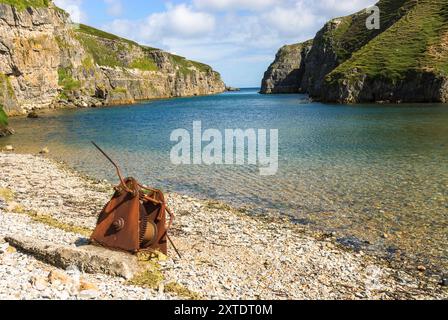 Découvrez le paysage captivant de Smoo Cave dans les Highlands, où les falaises de calcaire rencontrent des eaux sereines et une végétation luxuriante. Banque D'Images