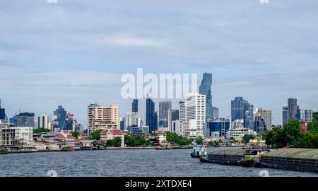 Cette image capture la superbe ligne d'horizon de Bangkok, avec un mélange de gratte-ciel modernes et de temples historiques le long de la rivière Chao Phraya. Les juxtapos Banque D'Images
