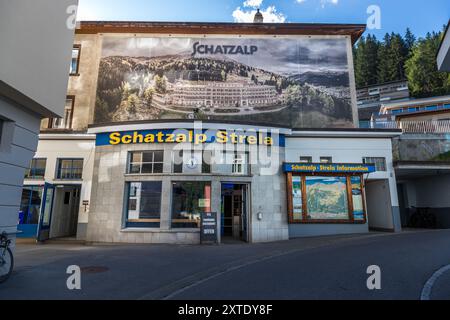 L’entrée du chemin de fer Schatzalp-Strela affiche une grande photographie historique du sanatorium Schatzalp au-dessus du guichet. Le funiculaire a été construit à la fin du XIXe siècle comme ligne d’alimentation du sanatorium. Avec la construction du téléphérique Strela, il s’est développé au XXe siècle en une voie d’accès à la zone de ski Schatzalp/Strela, symbolisant les débuts du tourisme d’hiver à Davos. Rosenhügelweg, Davos, Grisons, Suisse. Banque D'Images