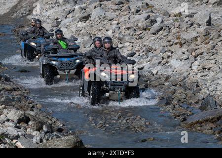 Khibiny, RUSSIE - 27 JUILLET 2024 : les touristes en VTT roulent le long du lit de la rivière Kuniyok par une journée ensoleillée. Chaîne de montagnes Khibiny. Région de Mourmansk Banque D'Images