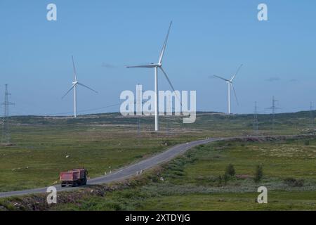 RÉGION DE MOURMANSK, RUSSIE - 29 JUILLET 2024 : générateurs d'énergie éolienne de la centrale éolienne de Kola et une autoroute dans la toundra un jour de juillet Banque D'Images