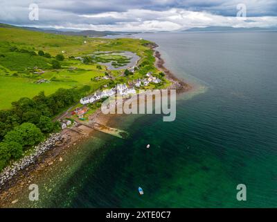 Le village pittoresque de Milltown, Applecross embrasse le rivage, entouré d'une végétation luxuriante et d'une mer calme sous un ciel couvert. Banque D'Images