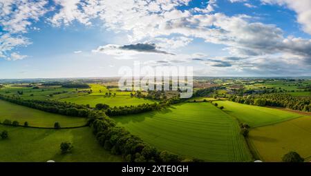 Des champs verdoyants avec des haies s'étendent à travers le paysage sous un ciel partiellement nuageux dans le North Yorkshire. Banque D'Images