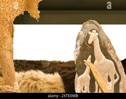 Girafes en sculpture entourées de peaux d'animaux et de peaux de fourrure. L'espace texte isolé est pour l'annonce, le signe et l'accent mis sur la faune ou la vie exotique. Banque D'Images