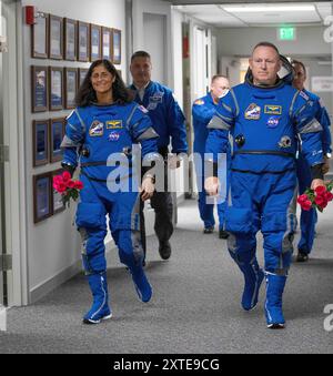 Cap Canaveral, Floride, États-Unis. 14 août 2024. L'astronaute de la NASA Butch Wilmore, à droite, et son camarade d'équipage Suni Williams, à gauche, tenant des roses, marchent depuis le Neil A. Armstrong Operations and Checkout Building pour le court voyage au Launch Complex 41. (Crédit image : © Kim Shiflett/NASA/ZUMA Press Wi Banque D'Images