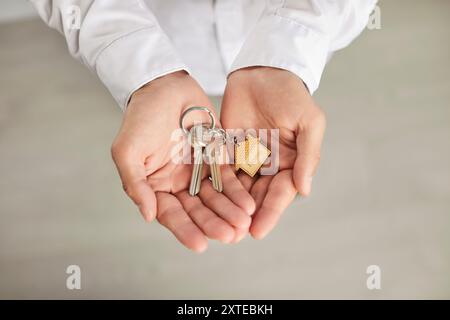 Gros plan des mains tenant les clés d'une nouvelle maison Banque D'Images
