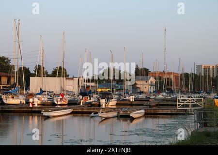 Belleville Marina, Ontario, présentant un port serein rempli de voiliers amarrés au coucher du soleil. Banque D'Images