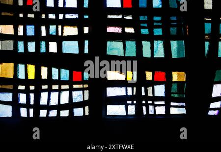 Vitrail abstrait avec des motifs rectangulaires et carrés colorés dans les tons de bleu, rouge, vert, jaune et noir. Banque D'Images