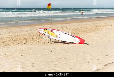 La planche de surf et les drapeaux des Life Guards avertissent les mers agitées de ne pas nager sur la Gold Coast, Queensland, Australie. Banque D'Images