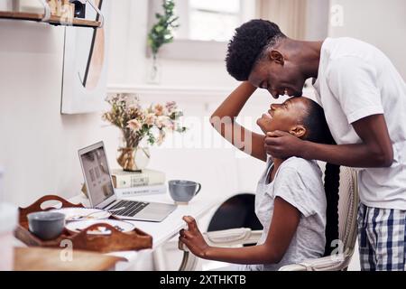 Ordinateur portable, matin et travail à distance avec couple noir en pyjama ensemble pour le début de l'emploi freelance. Amour, romance ou sourire avec l'homme africain heureux Banque D'Images