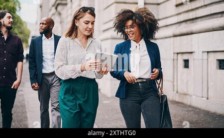 Affaires, femmes et tablette en ville avec discussion sur les trajets quotidiens, les voyages et la marche dans la conversation. Professionnel, équipe d'entreprise et employés sur Banque D'Images