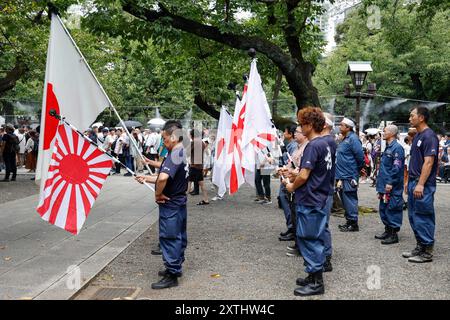 Tokyo, Japon. 15 août 2024. Les nationalistes japonais tiennent les drapeaux de guerre de l'armée impériale japonaise pendant le 79e anniversaire de la reddition du Japon lors de la première Guerre mondiale. Le premier ministre Fumio Kishida n'était pas parmi les législateurs à visiter le sanctuaire et a plutôt envoyé une offre rituelle pour éviter de mettre en colère les pays voisins qui associent également Yasukuni à les criminels de guerre et le passé impérial du Japon. (Crédit image : © Rodrigo Reyes Marin/ZUMA Press Wire) USAGE ÉDITORIAL SEULEMENT! Non destiné à UN USAGE commercial ! Banque D'Images