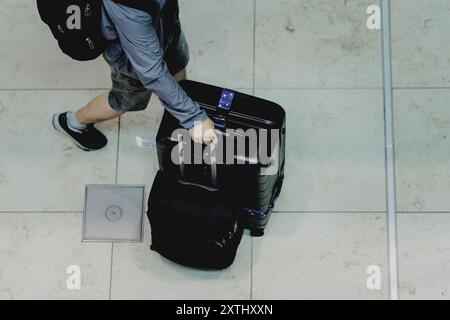 Schoenefeld, Deutschland. 12 août 2024. Voyageur avec valise, photographié à l'aéroport de Berlin Brandenburg 'Willy Brandt' (BER) à Schoenefeld, le 12 août 2024. Crédit : dpa/Alamy Live News Banque D'Images