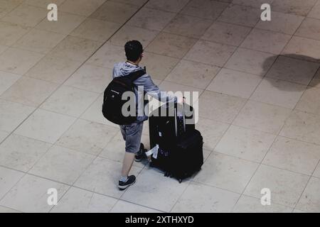 Schoenefeld, Deutschland. 12 août 2024. Voyageur avec valise, photographié à l'aéroport de Berlin Brandenburg 'Willy Brandt' (BER) à Schoenefeld, le 12 août 2024. Crédit : dpa/Alamy Live News Banque D'Images