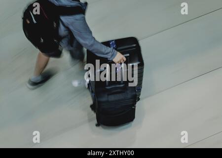 Schoenefeld, Deutschland. 12 août 2024. Voyageur avec valise, photographié à l'aéroport de Berlin Brandenburg 'Willy Brandt' (BER) à Schoenefeld, le 12 août 2024. Crédit : dpa/Alamy Live News Banque D'Images