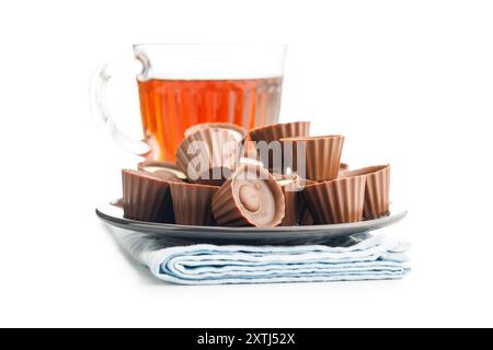 Pralines sucrées. Truffes au chocolat et tasse de thé isolé sur un fond blanc. Banque D'Images