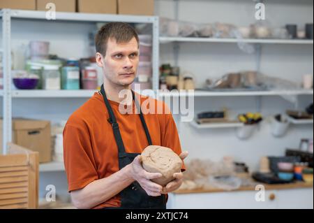 Potter pétrit l'argile avant de l'utiliser dans l'atelier. Banque D'Images