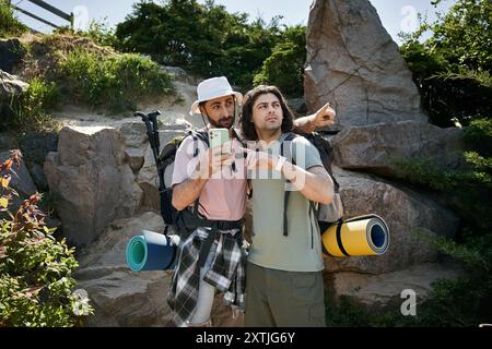 Deux jeunes hommes, un couple gay, partent ensemble en randonnée dans la nature sauvage estivale, profitant de la compagnie de l'autre. Banque D'Images