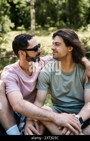 Un jeune couple gay profite d'une randonnée dans les bois par une chaude journée d'été. Banque D'Images