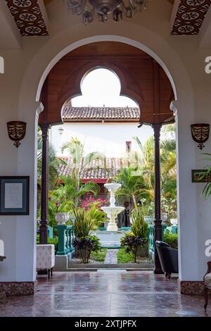 Grenade, Nicaragua - 20 mars 2024 : entrée dans le bâtiment colonial de l'hôtel avec vue à travers le jardin et la fontaine à Grenade sur les rives du lac Nicaragua Cocibolca au Nicaragua Amérique centrale Banque D'Images