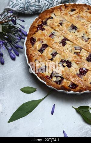 Tarte au treillis de myrtille fraîchement cuite sur une table. Belle croûte dorée en gros plan. Gâteau rond sucré maison. Fond gris clair avec espace de copie Banque D'Images