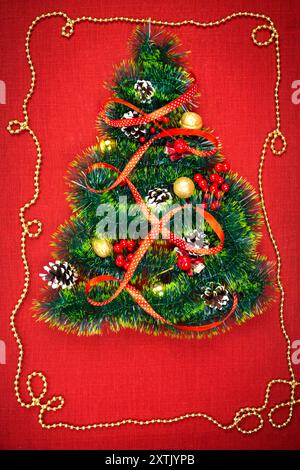 Un petit arbre de Noël de guirlandes, de noix, de rubans et d'ornements. Cadeau pour un sapin de Noël, une montre vintage. 2018, Banque D'Images