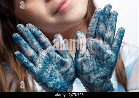 Mains d'enfant de couleur bleue après l'activité de peinture vue rapprochée Banque D'Images